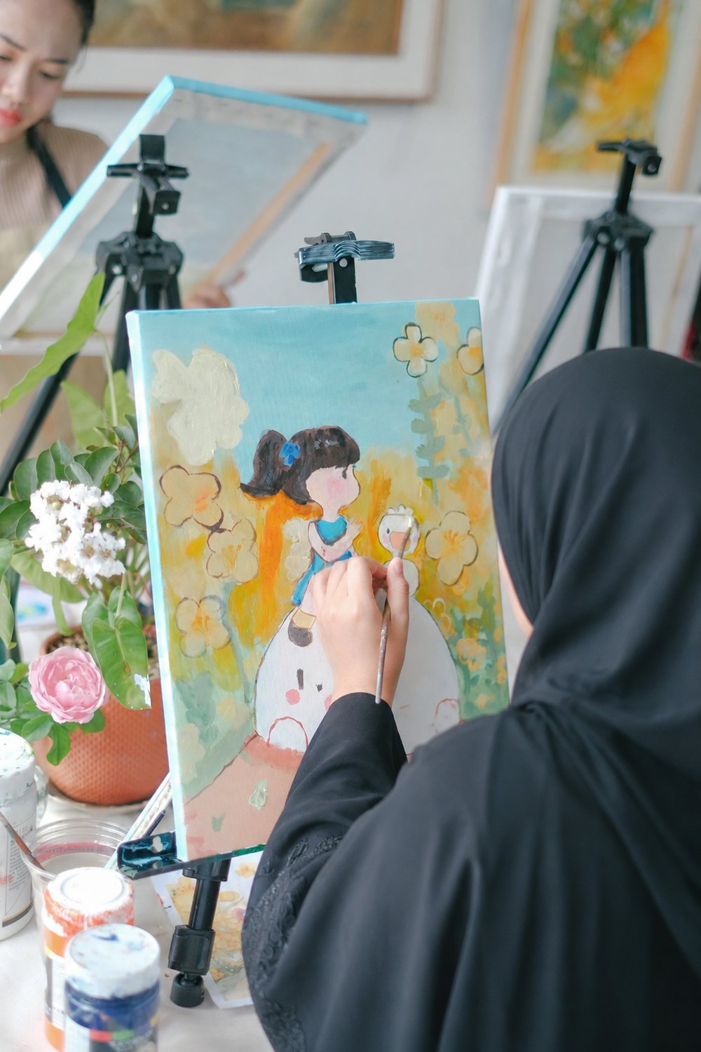متدربة ترسم على الحامل في مرسم ميان